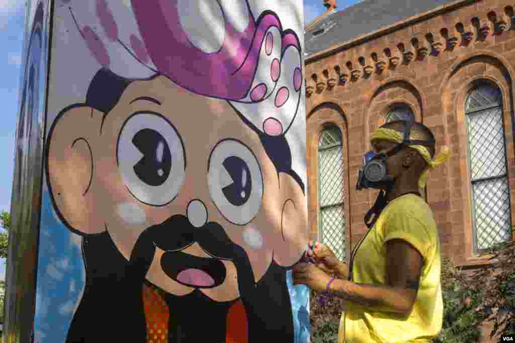 Artist &ldquo;Superwaxx&rdquo; does a stylized portrait of Japanese contemporary artist Takashi Murakami outside of the S. Dillon Ripley Center. (T. Hart/VOA)