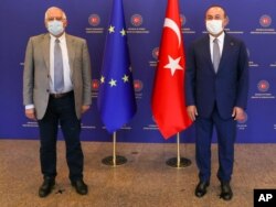 Turkey's Foreign Minister Mevlut Cavusoglu, right, and Josep Borrell Fontelles, High Representative and Vice-President of the European Commission, pose for photos before a meeting, in Ankara, Turkey, July 6, 2020.