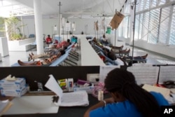 FILE - People get treatment at Haiti's first permanent cholera center, run by Gheskio Centers, in downtown Port-au-Prince, Haiti, Feb. 24, 2016.