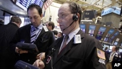 Gordon Charlop, right, works with fellow traders on the floor of the New York Stock Exchange. (March 2012 file photo)
