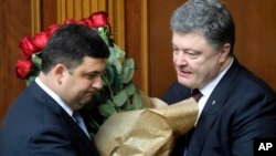 Ukraine's President Petro Poroshenko, right, and Volodymyr Groysman celebrate after Groysman was appointed prime minister during a parliament session in Kyiv, Ukraine, April 14, 2016, after lawmakers endorsed Arseniy Yatsenyuk’s resignation.