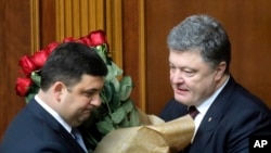 FILE - Ukraine's President Petro Poroshenko, right, and Volodymyr Groysman celebrate after Groysman was appointed prime minister during a parliament session in Kyiv, Ukraine, April 14, 2016, after lawmakers endorsed Arseniy Yatsenyuk’s resignation.