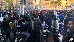 En esta foto tomada por un individuo no empleado por Associated Press y obtenida por la AP fuera de Irán, manifestantes se reúnen para protestar contra la debilitada economía de Irán, en Teherán, Irán, el sábado 30 de diciembre de 2017.