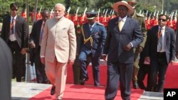 Indian Prime Minister Narendra Modi, centre left, is received by President Yoweri Museveni, centre right, after inspecting a parade at State House Entebbe, about 42 km from the capital Kampala Monday July 24, 2018. Modi has embarked on a five-day three-nation tour of the African continent.