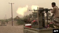 FILE - Image grab taken from a AFPTV video shows Yemeni pro-government forces firing a heavy machine gun at the south of Hodeida airport, in Yemen's Hodeida province on June 15, 2018.