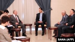 Syrian President Bashar al-Assad, center, meets with a Russian delegation of parliamentarians in Damascus, Syria, in a handout picture released by the Syrian Arab News Agency, Oct. 25, 2015. 
