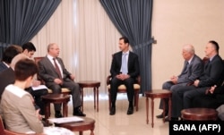 Syrian President Bashar al-Assad, center, meets with a Russian delegation of parliamentarians in Damascus, Syria, in a handout picture released by the Syrian Arab News Agency, Oct. 25, 2015.