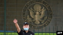 美国驻北京大使馆外的一名中国保安在做手势。（2020年9月12日）