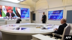 俄罗斯国家卫星通讯社发布的这张照片显示，中国国家主席习近平和俄罗斯总统弗拉基米尔·普京出席金砖国家集团（包括巴西、俄罗斯、印度、中国和南非）的虚拟峰会.