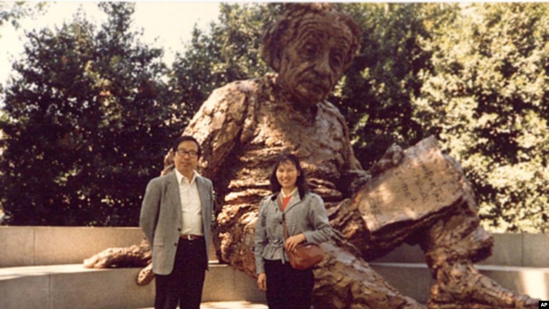 李淑娴和方励之1986年在华盛顿的美国科学院大门前的爱因斯坦雕像前合影。爱因斯坦手上的一张纸写有三个公式(从下到上):E=mc2;光电效应;广义相对论方程。注意:广义相对论方程中没有宇宙常数项
