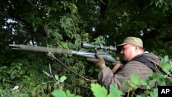 A pro-Russian fighter aims his sniper rifle in Slovyansk, Ukraine, June 11, 2014. 