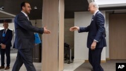 U.N. Special Envoy for Syria Staffan de Mistura, right, prepares to shake hands with Syria's main opposition High Negotiations Committee leader Nasr al-Hariri upon his arrival for a meeting during Syria peace talks in Geneva, Switzerland, Feb. 27, 2017.