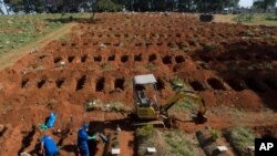 Cemetery workers exhume remains buried three years ago at the Vila Formosa cemetery, which does not charge families for the gravesites, in Sao Paulo, Brazil, June 12, 2020. They're making room for COVID-19 victims.