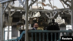 Henry Hamra, who is visiting Syria for the first time in decades, stands next to a menorah in a synagogue in Damascus, Syria, Feb. 18, 2025.