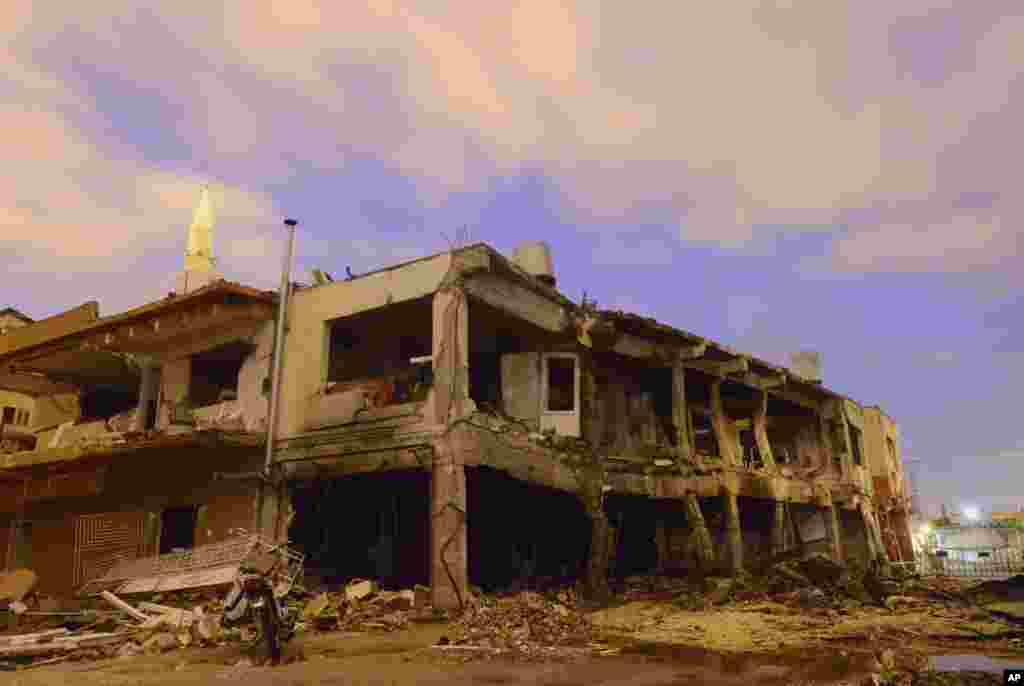 Stars are seen in the sky with a destroyed building on a street littered with debris from one of the explosion sites in Reyhanli, near Turkey's border with Syria.