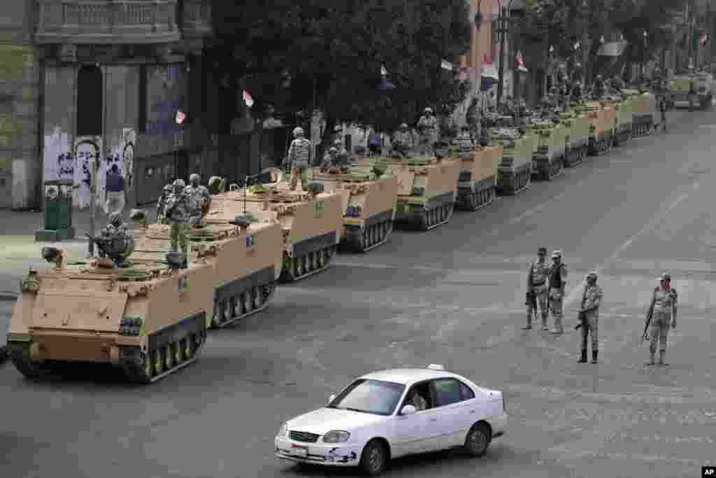 Egyptian army soldiers take their positions on top and next to their armored vehicles while guarding an entrance to Tahrir square, in Cairo, Egypt, Friday, Aug. 16, 2013.