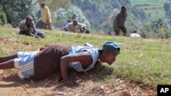 Demonstrators opposed to a third term for President Pierre Nkurunziza in Burundi dive to the ground as army soldiers shoot in the air to disperse the protest, in the rural area of Mugongomanga, east of the capital, Bujumbura, June 10, 2015. 