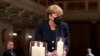 German Chancellor Angela Merkel holds a candle during a memorial service in Berlin, in remembrance of the country&#39;s COVID-19 dead.