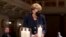 German Chancellor Angela Merkel holds a candle during a memorial service in Berlin, in remembrance of the country's COVID-19 dead.