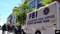 Mobil FBI, yang mengangkut tim untuk mengumpulkan bukti, diparkir di luar markas angkatan laut Washington (18/9). (AP/U.S. Navy)