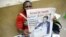 An Angolan newspaper street seller holds up a copy of the national paper in the street of Luanda, September 1, 2012. 
