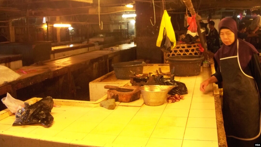 Seorang pedagang daging ayam di Pasar Kosambi Bandung merapikan lapak tempatnya berjualan, sebelum memulai aksi mogok berjualan (foto: VOA/Wulan)