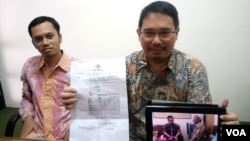 Ketua Tim Pembela Kemanusiaan, Trisno Raharjo (kanan) menunjukkan surat pemanggilan polisi kepada Mardiyo, ayah almarhum Siyono dan foto di kantor Polisi. Sebelah kiri Eko Riyadi dari Pusat Studi Hukum dan HAM - UII.