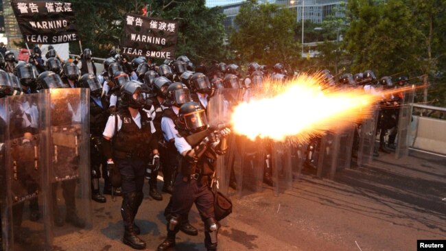 一名警察在《逃犯条例》抗议游行中，使用催泪瓦斯。(2019年6月12日)