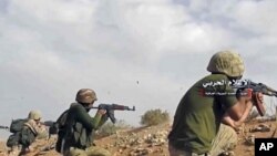 This frame grab from video provided Nov. 8, 2017, by the government-controlled Syrian Central Military Media, shows Syrian pro-government troops taking up positions and firing on militants' positions on the Iraq-Syria border. 