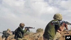 This frame grab from video provided Nov. 8, 2017, by the government-controlled Syrian Central Military Media, shows Syrian pro-government troops taking up positions and firing on militants' positions on the Iraq-Syria border.