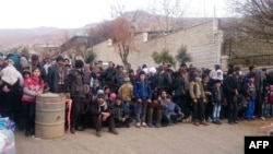 Syrians wait for the arrival of an aid convoy, Jan. 11, 2016, in the besieged town of Madaya.