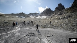 星期日，數百名哀悼者聚集在一起,穿著哀悼的衣服，在瑞士東部的阿爾卑斯山脈的格拉魯斯跋涉數小時，到達海拔2600米的殘留比索冰川。
