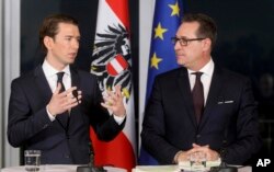 FILE - Leader of the Austrian People's Party, Sebastian Kurz, and Heinz-Christian Strache, chairman of the right-wing Freedom Party, talk during a joint news conference after forming a new coalition government in Vienna, Austria, Dec. 16, 2017.