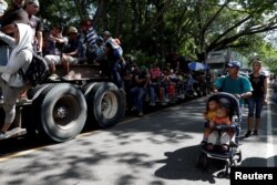Central American migrants, part of a second wave of migrants heading to the U.S., hitchhike on a truck as they continue their journey to the Mexican border, in Chiquimula, Guatemala, Oct. 23, 2018.