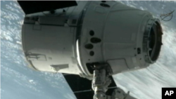 Kapsul Dragon buatan perusahaan SpaceX ditangkap dengan lengan robot oleh para astronot stasiun antariksa internasional (25/5).