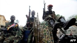 FILE - Child soldiers of the Seleka coalition sits on a pickup truck near the Presidential palace in Bangui, March 25, 2013. 