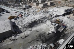 Arhiva - Uništene zgrade snmljene 12. avgusta 2018, nakon eksplozije skladišta sa oružjem u stambednom delu grada Sarmade, u severnoj sirijskoj provinciji Idlib.