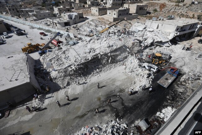 2018年8月12日、シリアのイドリブ州の都市Sarmadaの住宅地にある武器庫で爆発が起こった後、破壊された建物が見られる。