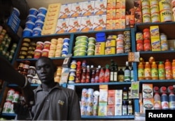 FILE - A shopkeeper receives payment in a roadside kiosk in Senegal's capital Dakar.