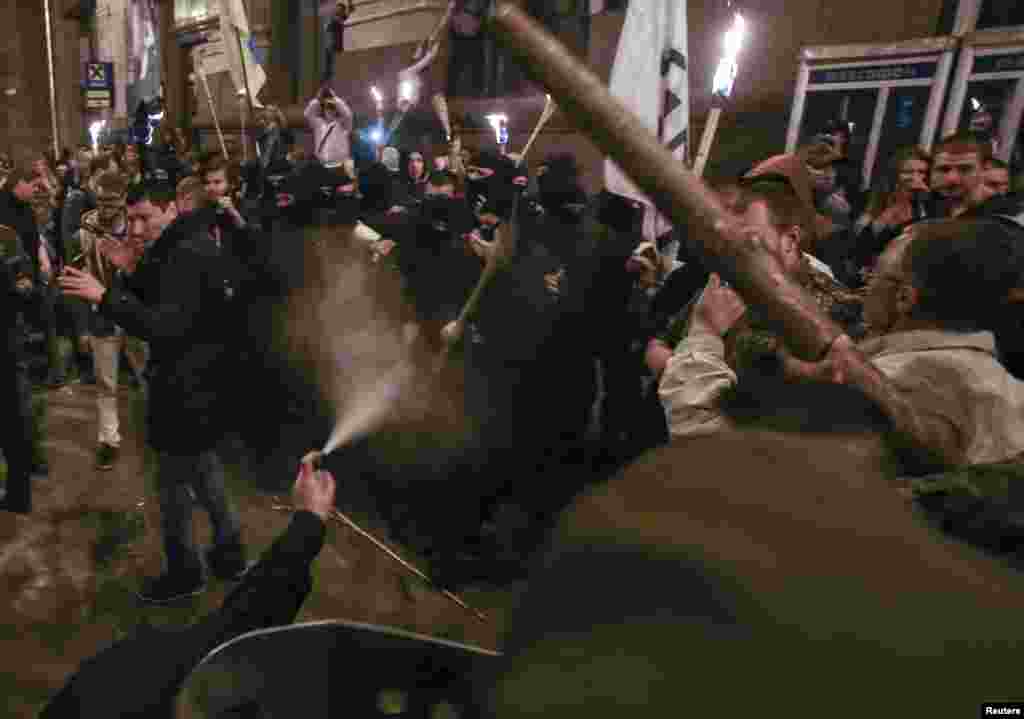 Members of self-defense units of the Euromaidan movement (front) attack members and supporters of Ukrainian far-right radical groups (back) to prevent them from taking part in a torchlight procession, Kyiv, April 29, 2014.