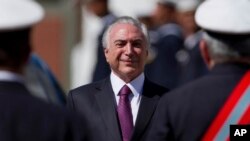 Brazil's President Michel Temer smiles as he receives military honors during a ceremony, in Brasilia, June 9, 2017.