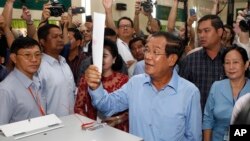 已经统治了33年的柬埔寨首相洪森带着他的妻子到达金边郊区的电视台投票（2018年7月30日）