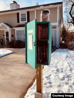 Toples berisi biskuit anjing diletakkan di atas Little Free Library di Mount Prospect, Illinois. (Courtesy: Alfred Ticoalu)
