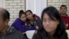 FILE - Central American migrants embrace as they wait for assistance at a center for newly-arrived migrant families with children, at Sacred Heart Catholic Church in McAllen, Texas. Assistance includes clothes, a meal, a shower and access to medical care.