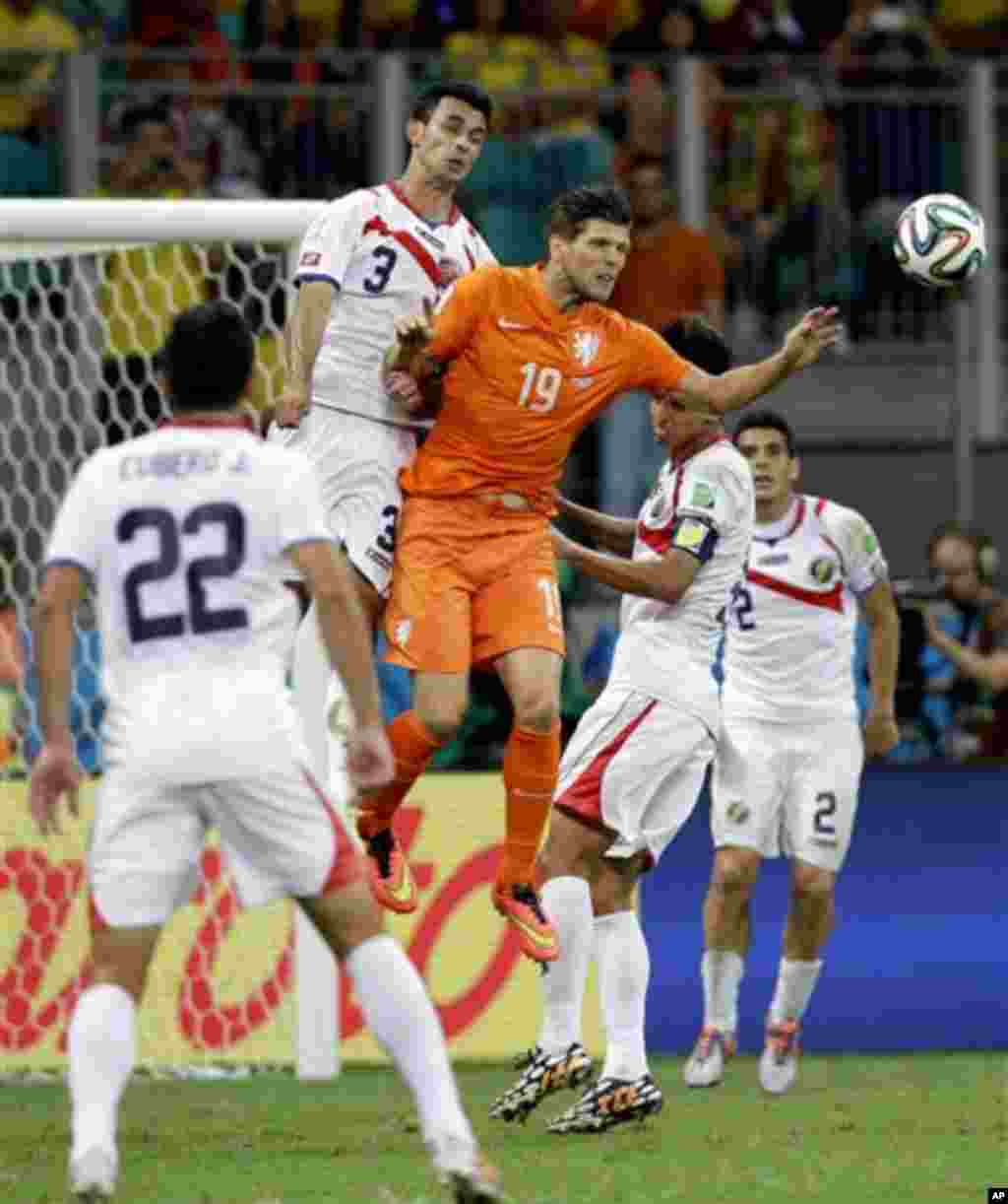 Netherlands' Klaas-Jan Huntelaar (19) and Costa Rica's Giancarlo Gonzalez (3) go for a header during the World Cup quarterfinal soccer match between the Netherlands and Costa Rica at the Arena Fonte Nova in Salvador, Brazil, Saturday, July 5, 2014. (AP Ph