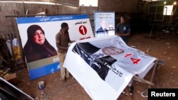 Workers prepare election campaign posters for Libya's House of Representatives in Tripoli, June 18, 2014