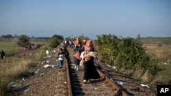 Mwanamke na watoto wake akitumia njia ya Reli kuelekea kwenye mpaka wa Serbia na Hungary