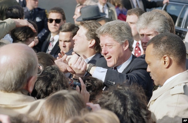 FILE - President-elect Bill Clinton and Vice President-elect Al Gore shake hands with supporters following church services in Culpeper, Virginia, Jan. 17, 1993. (AP Photo/Greg Gibson)