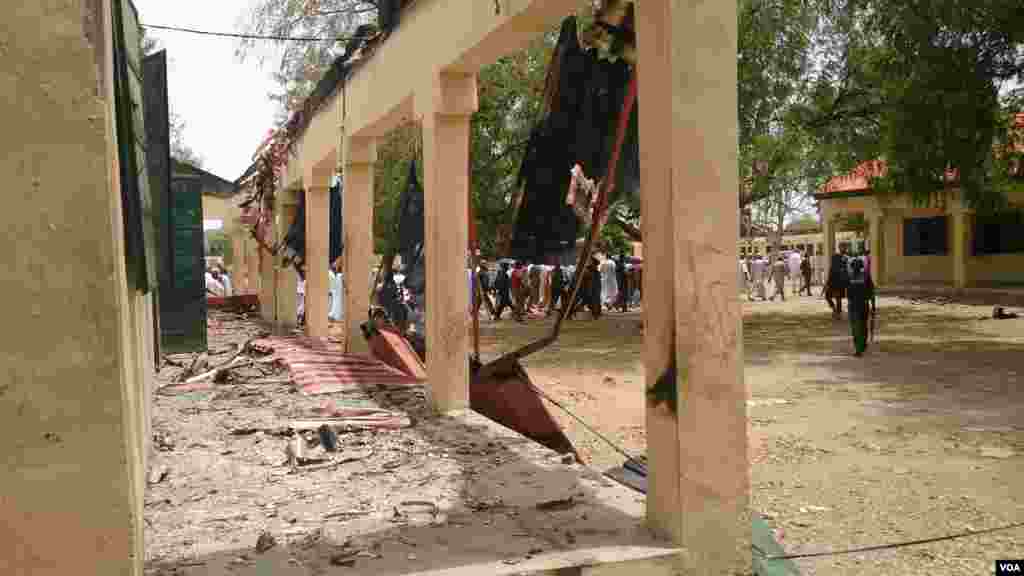 An entourage of Chibok&#39;s governor, the local education commissioner, armed security and townspeople walk to the site of the burned out government secondary school, Chibok, Nigeria, April 21, 2014. (Anne Look/VOA)