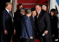 President Donald Trump, left, with first lady Melania Trump, watch Secretary of State Mike Pompeo, right, embrace former North Korean detainee Tony Kim, with Kim Hak Song, third from left, and Kim Dong Chul, front, May 10, 2018.